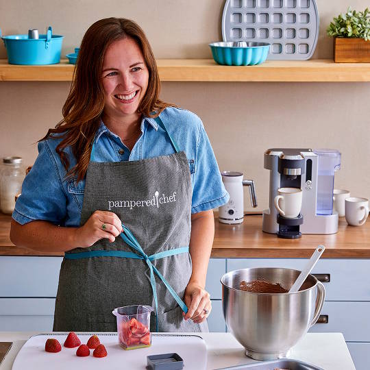 a consultant wearing a pampered chef apron working in a kitchen