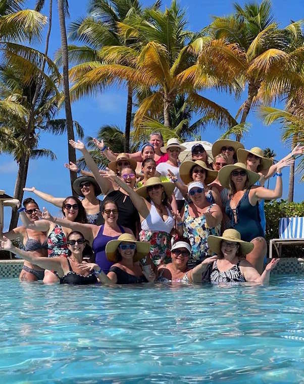 consultants at a pool with palm trees in the background