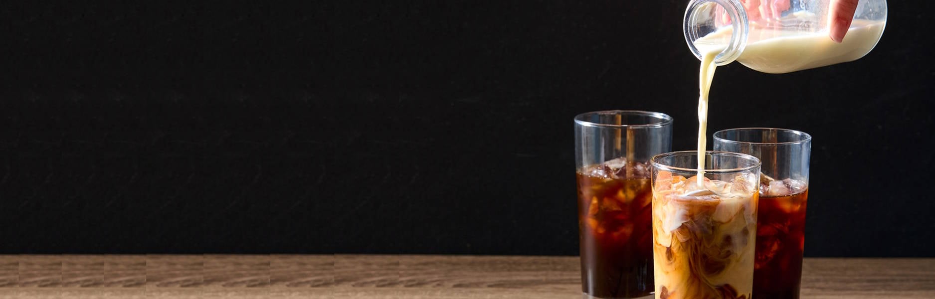 Pouring milk into iced coffee