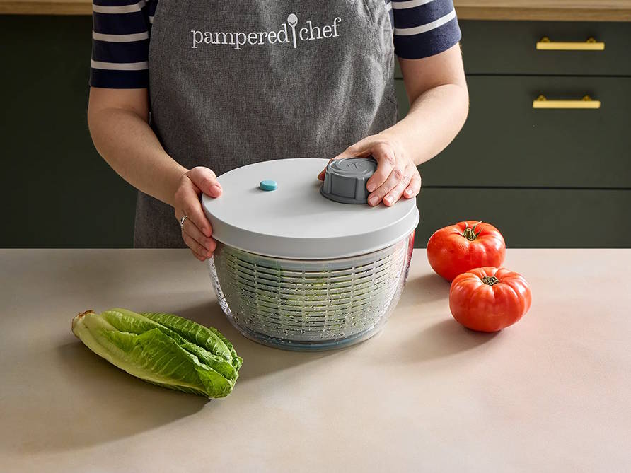 Someone spinning a salad in the berry and salad spinner